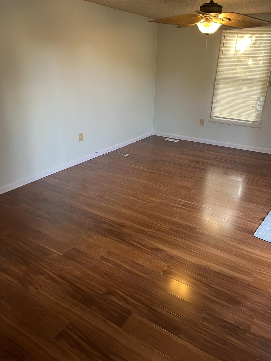 Empty room with newly finished dark hardwood-style flooring