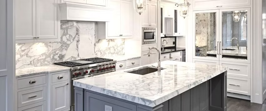 Finished kitchen with marble island, white cabinetry, and integrated appliances