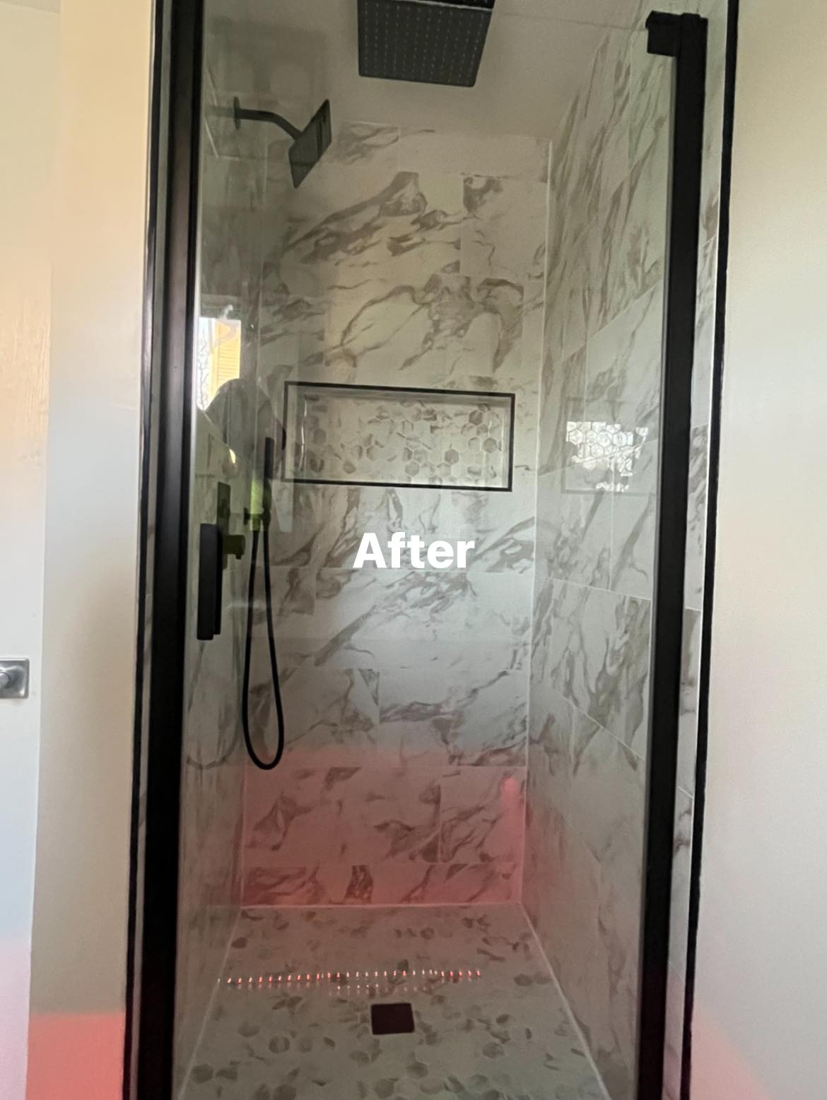 Completed walk-in shower after renovation with glass door and tiled walls